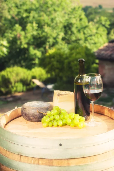 Vinho tinto, queijo pecorino num barril de madeira ao fundo o — Fotografia de Stock