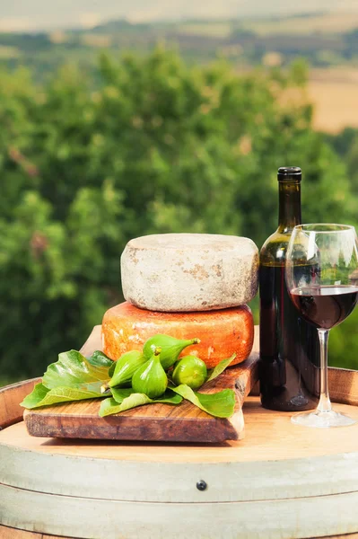 Vino tinto, queso, higos en un barril de madera en el fondo de t —  Fotos de Stock