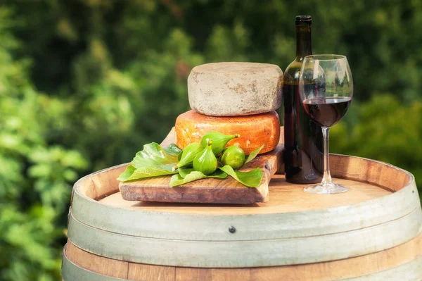 Rotwein, Käse, Feigen auf einem Holzfass im Hintergrund von t — Stockfoto