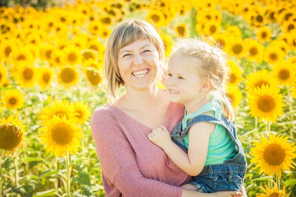 Mamá con hija entre hermosos girasoles en el día de verano . — Foto de Stock