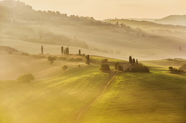 Wiejski krajobraz Toskanii w mglisty poranek słoneczny — Zdjęcie stockowe