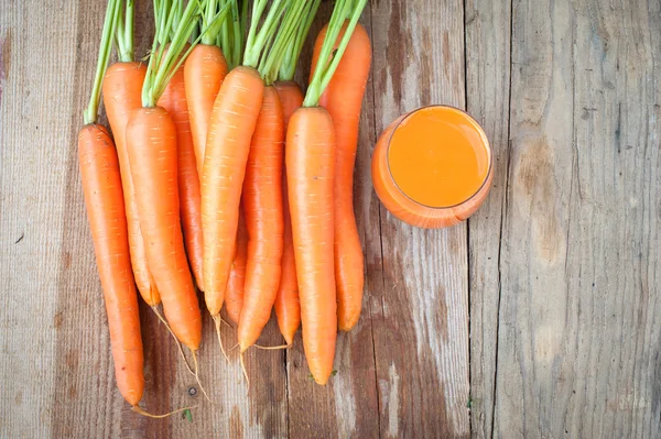 Свіжа морква і сік на дерев'яному сільському столі Вінтаж — стокове фото
