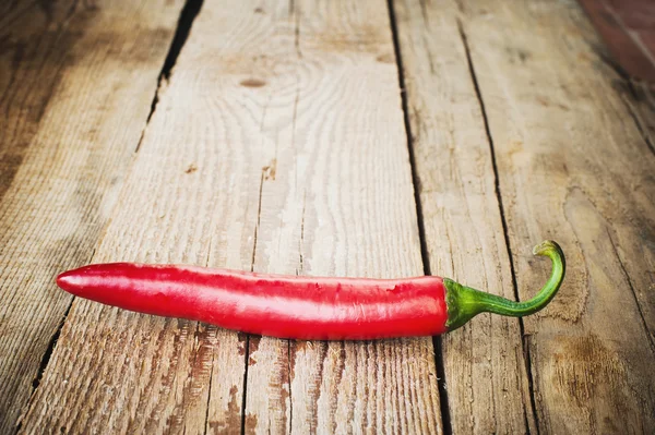 Peperoni succosi e piccanti su un tavolo rustico di legno — Foto Stock