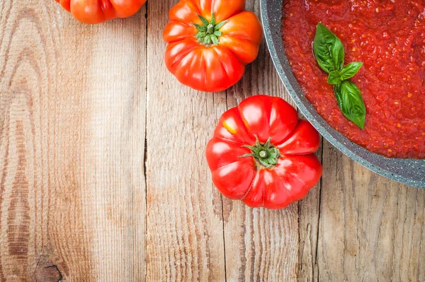 Tomato sauce in a pan with tomatoes around — Stock Photo, Image