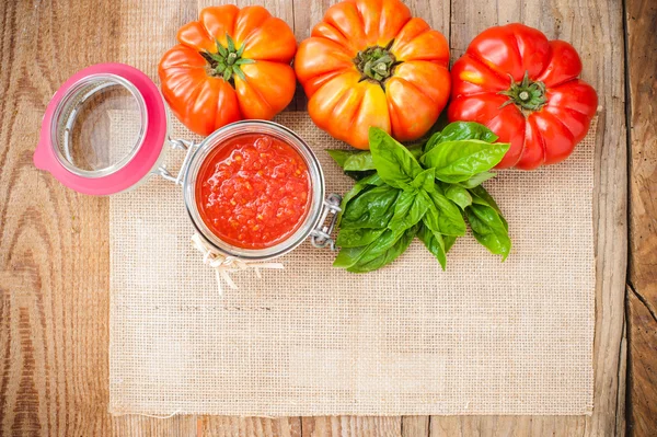 Tomates et sauce tomate, purée de tomates sur une table rustique en bois — Photo