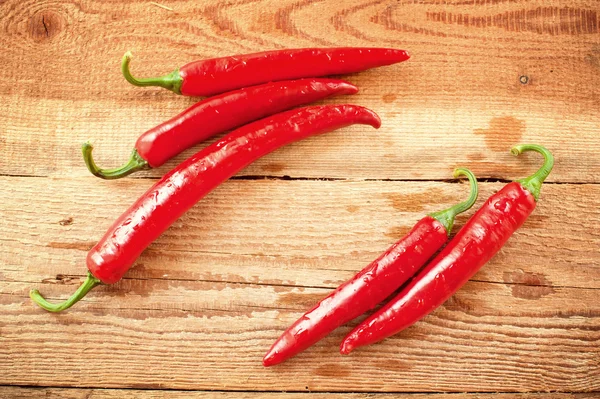 Svěží a pikantní chilli papričky na dřevěný rustikální stůl vinobraní — Stock fotografie