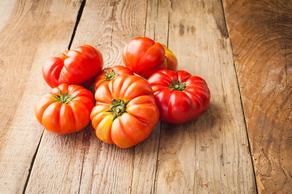 Pomodori rossi grandi su un tavolo rustico in legno in una bella giornata — Zdjęcie stockowe