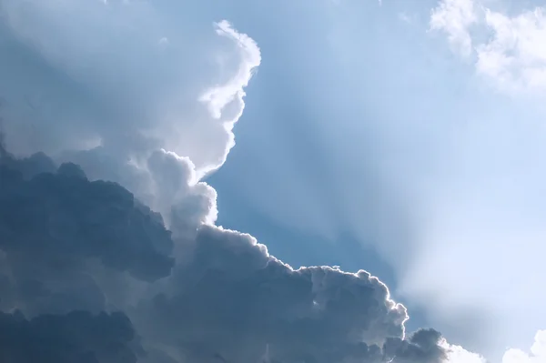 เมฆที่ส่องแสงบนท้องฟ้าสีฟ้า — ภาพถ่ายสต็อก