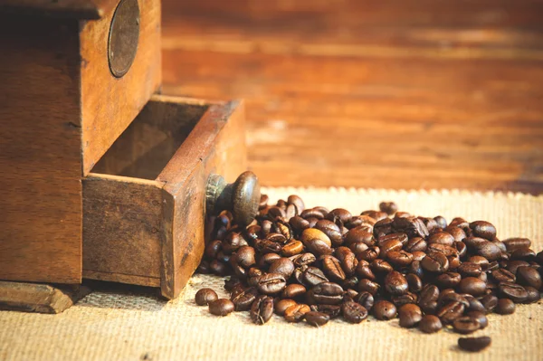 Molinillo de café con granos de café en una mesa rústica de madera — Foto de Stock