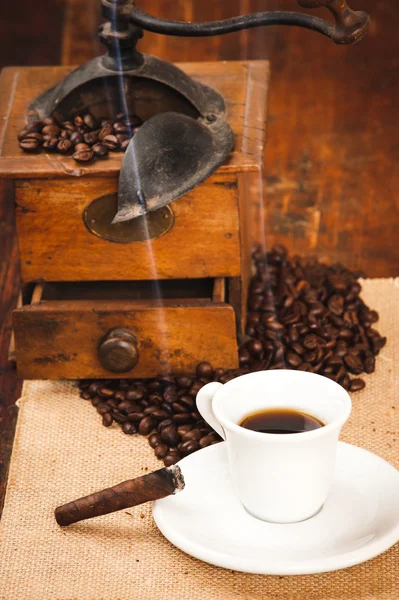 Copa de café negro y un cigarro en el molinillo de fondo en una w — Foto de Stock