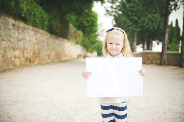 Милая маленькая девочка по дороге в школу с белой карточкой — стоковое фото