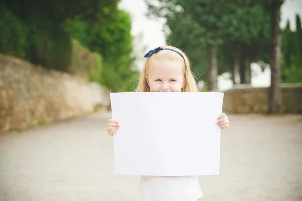 Милая маленькая девочка по дороге в школу с белой карточкой — стоковое фото