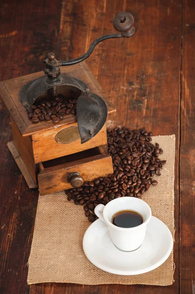 Taza de café negro en el molino de fondo en un rústico de madera — Foto de Stock