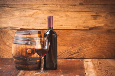 Kırmızı şarap bir şişe ile bir cam ve ahşap rustik ta namlu