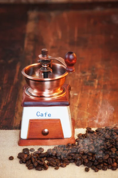 Coffee grinder with coffee grains on a wooden rustic table — Stock Photo, Image