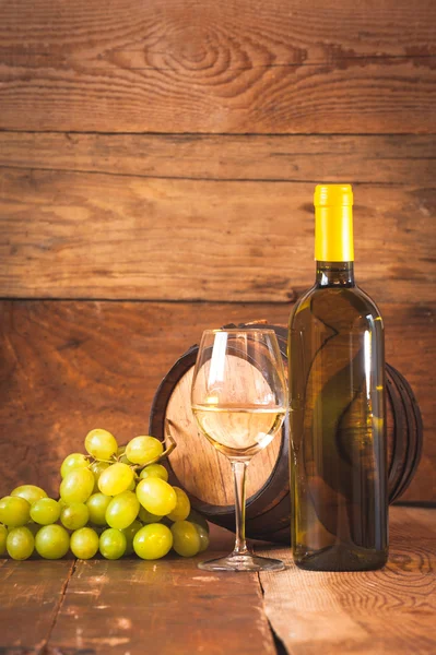 Bicchiere di vino bianco con bottiglia e botte su una rustica ta di legno — Foto Stock