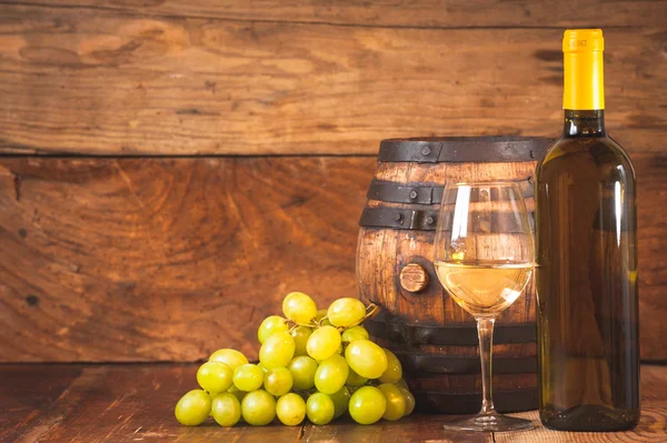 Copa de vino blanco con botella y barril en una ta de madera rústica — Foto de Stock