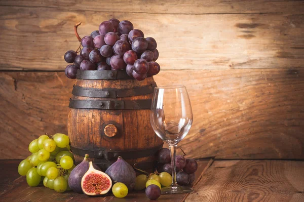 Uvas vermelhas e brancas em um barril de madeira rural — Fotografia de Stock