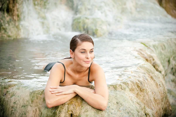 Jolie jeune femme prend un bain dans les eaux thermales naturelles de — Photo