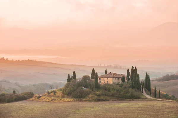Tuscany landschap in de mist bij zonsopgang — Stockfoto