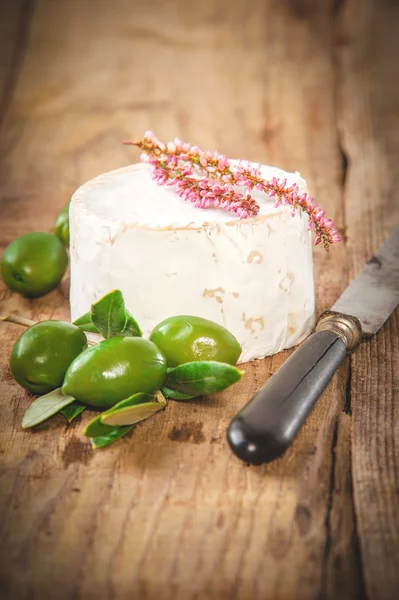 Smelly blue cheese on a wooden rustic table with green olives — Stock Photo, Image