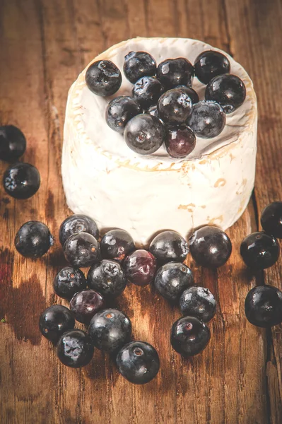 Вонючий голубой сыр на деревянном деревенском столе с черникой — стоковое фото