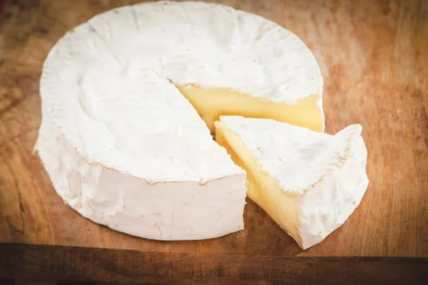 Smradlavý sýr camembert na dřevěný rustikální stůl — Stock fotografie