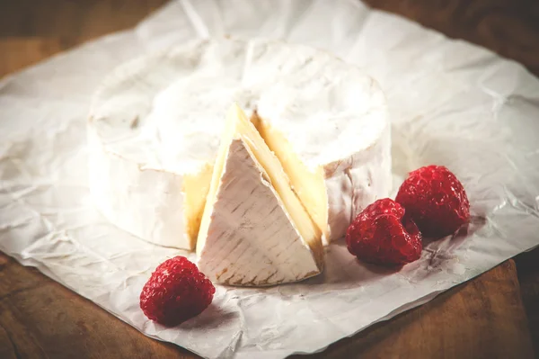 Smelly camembert cheese on a wooden rustic table with raspberrie — Stock Photo, Image