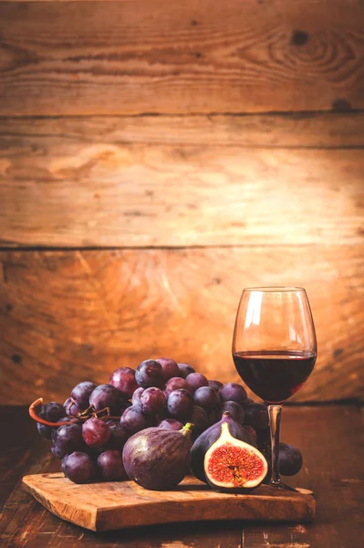 Fico con vino rosso, uva e botte su tavola in legno rustico — Foto Stock