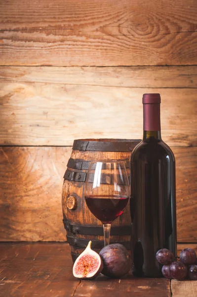 Fico con vino rosso, uva e botte su tavola in legno rustico — Foto Stock