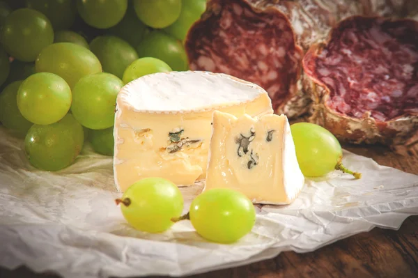 Queijo azul com salame em uma mesa rústica de madeira — Fotografia de Stock