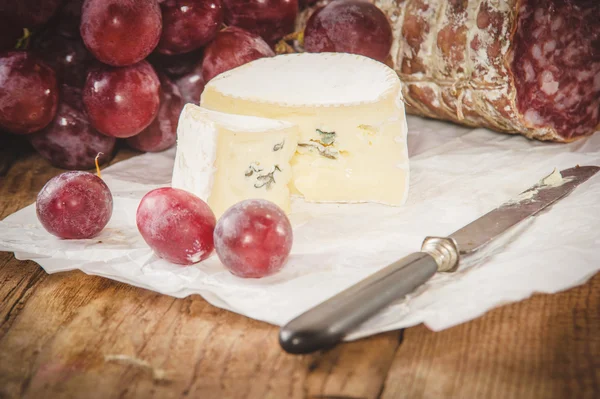 Blauschimmelkäse mit Salami auf einem rustikalen Holztisch — Stockfoto