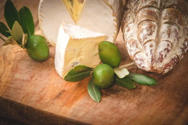 Смердючий блакитний сир на дерев'яному сільському столі з салямі та оливом — стокове фото
