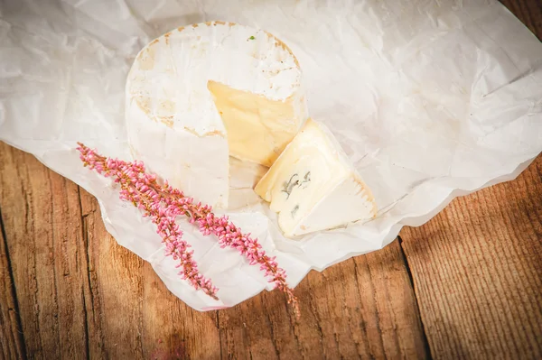 Smelly blue cheese on white paper a wooden rustic table — Stock Photo, Image