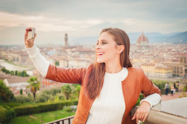 Hermosa mujer joven haciendo una foto con el fondo de Floren — Foto de Stock