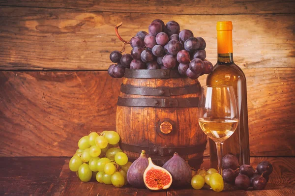 Fico con vino bianco, uva e botte su tavola in legno rustico — Foto Stock
