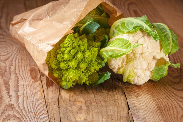 Romanesco brocoli et chou-fleur dans un sac en papier sur une ta en bois — Photo