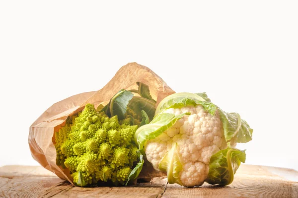 Broccoli romanesco e cavolfiore in un sacchetto di carta su una ta di legno — Foto Stock