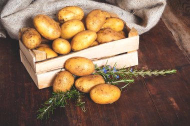 Rustik ahşap bir masa üzerinde bir kutu içinde patates