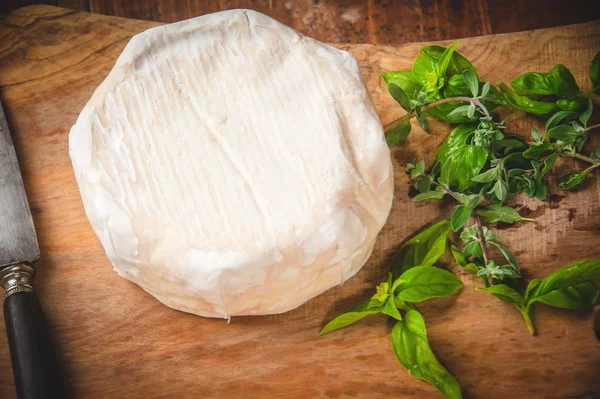 Formaggio blu puzzolente su un tavolo rustico in legno con coltello e basilico — Foto Stock