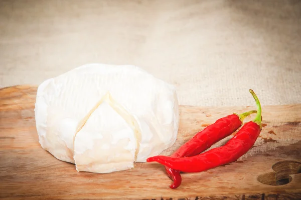 Smelly blue cheese on a wooden rustic table with hot chili peppe — Stock Photo, Image