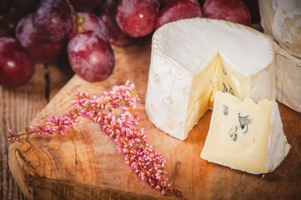 Smelly blue cheese on a wooden rustic table with grape — Stock Photo, Image
