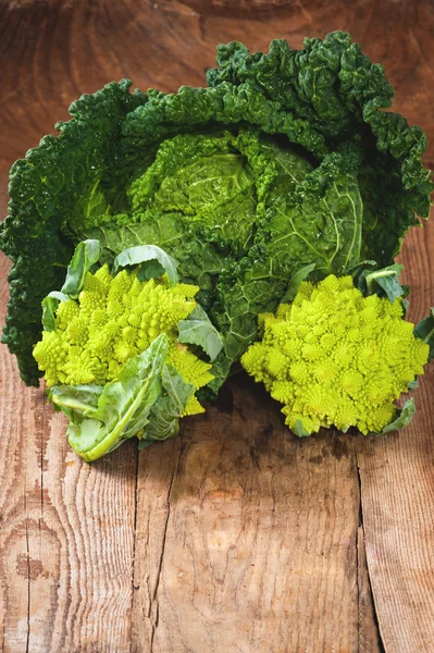 Savoy cabbage and Romanesco on a wooden rustic table — Stock Image Savoy cabbage and Romanesco on a wooden rustic table Stock Photo