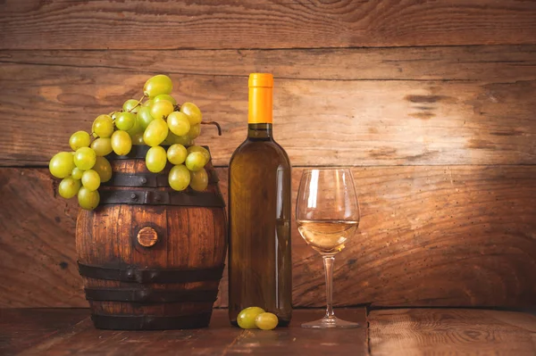 Glas Weißwein mit Flasche und Fass auf rustikalem Holzboden — Stockfoto