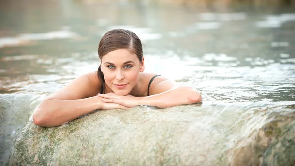 Pretty young woman takes a bath in the natural thermal waters of — Stock Photo, Image