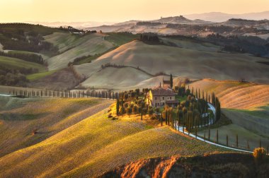Batan güneşin güzel manzaralar Tuscany'de selvi.