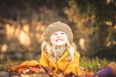 Güzel kız, sarışın gülümseyen sonbahar yaprakları ile çalış