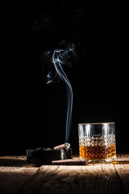 Alkol ve sigara asil puro siyah bir arka plan üzerinde bardak