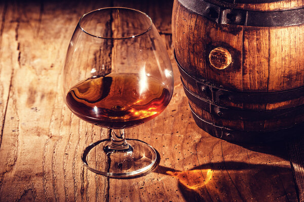 Strong alcohol on a wooden table and barrel