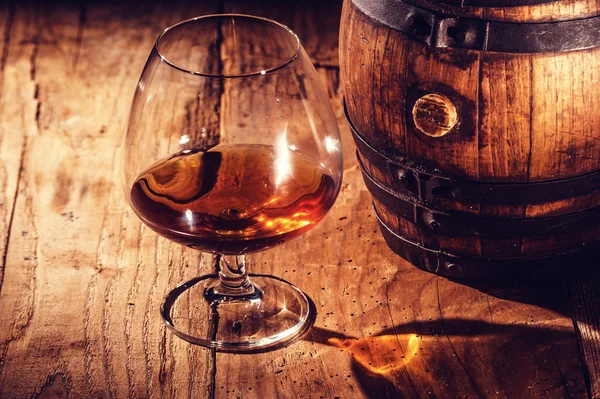 Strong alcohol on a wooden table and barrel Royalty Free Stock Images